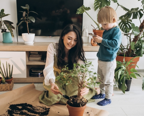 Madre con niño cultivando plantas en casa