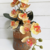 Detalle de las flores de orquídea artificial en tonos rosados y naranjas